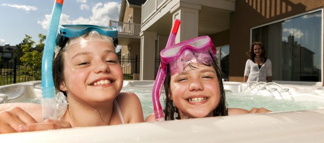 Two little girls have fun in a swim spa