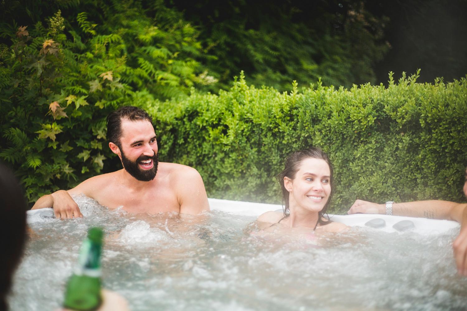 Smiling young couple enjoying their hot tub on a summer day
