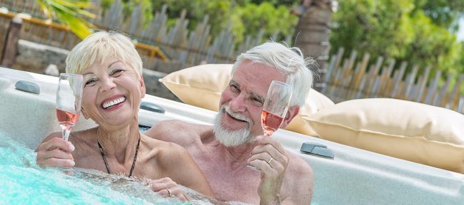 Senior couple drinking wine in hot tub