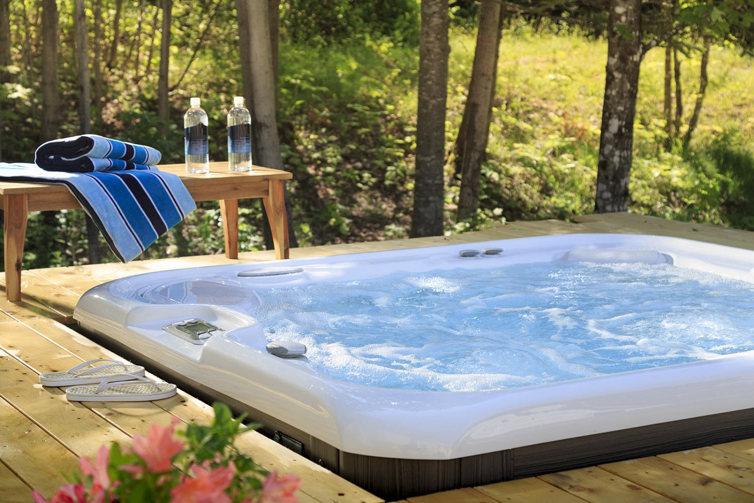 Hot tub on wooden deck with view of woods