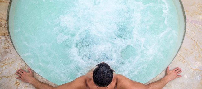 Man relaxing in a hot tub seen from above