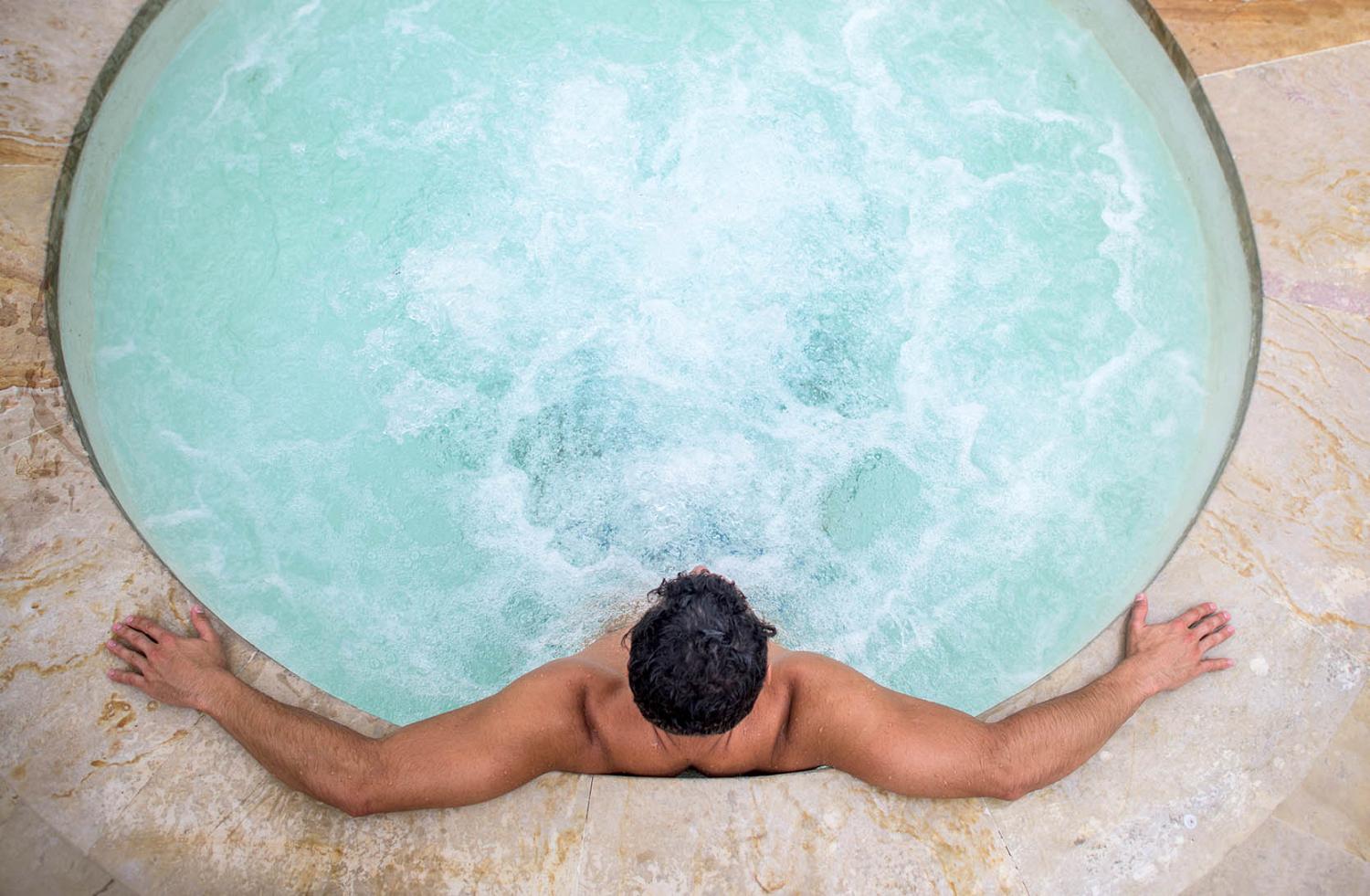 Man relaxing in a hot tub seen from above