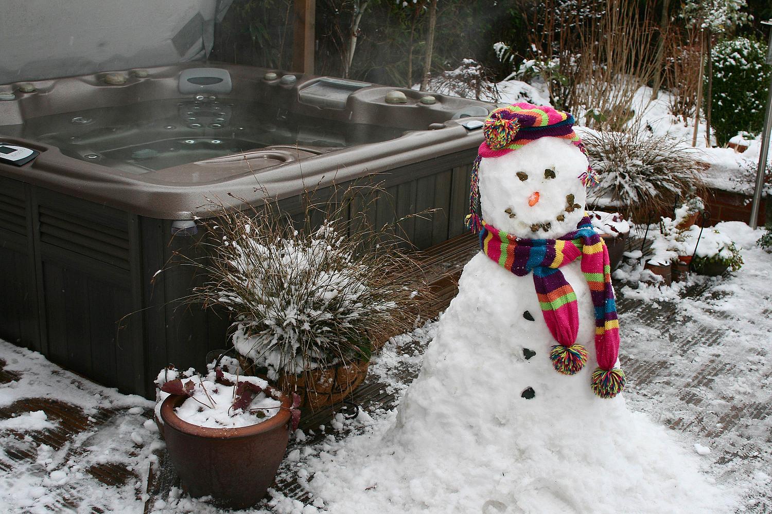 Hot tub spa outside with a snowman next to it