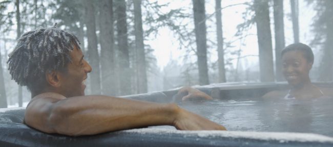 Smiling couple in outdoor hot tub in winter